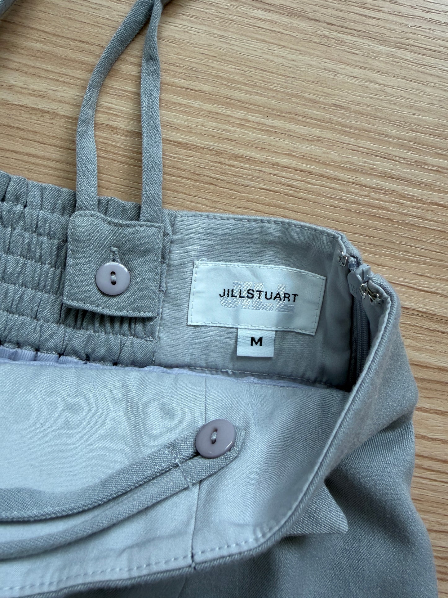 Close-up picture of inside of the JILLSTUART jumper skirt with tag saying "JILLSTUART M"