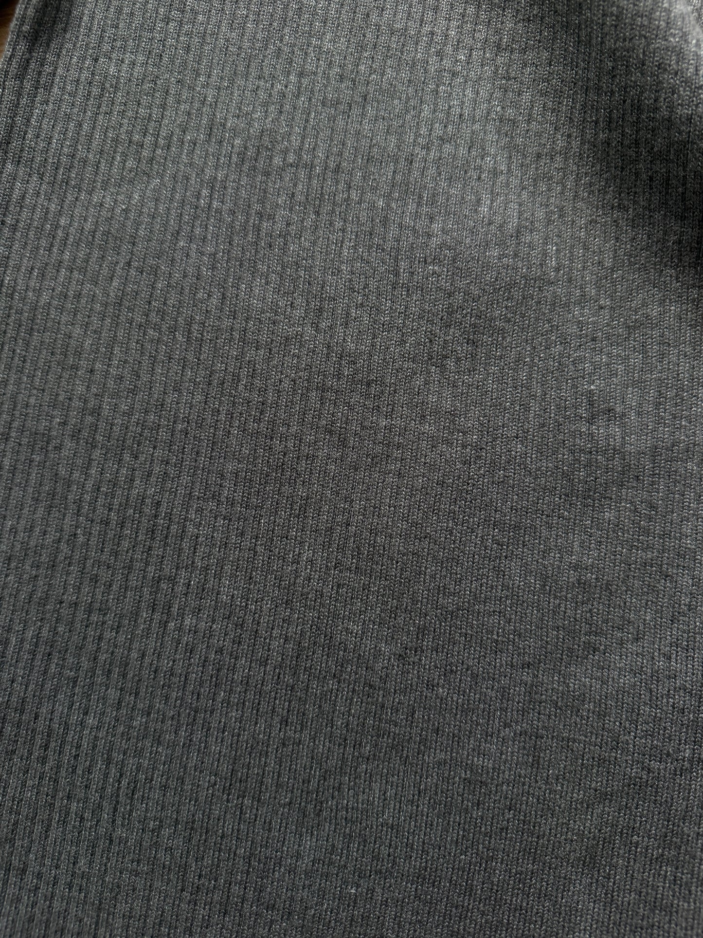 Close-up of a dark gray ribbed knit fabric texture.