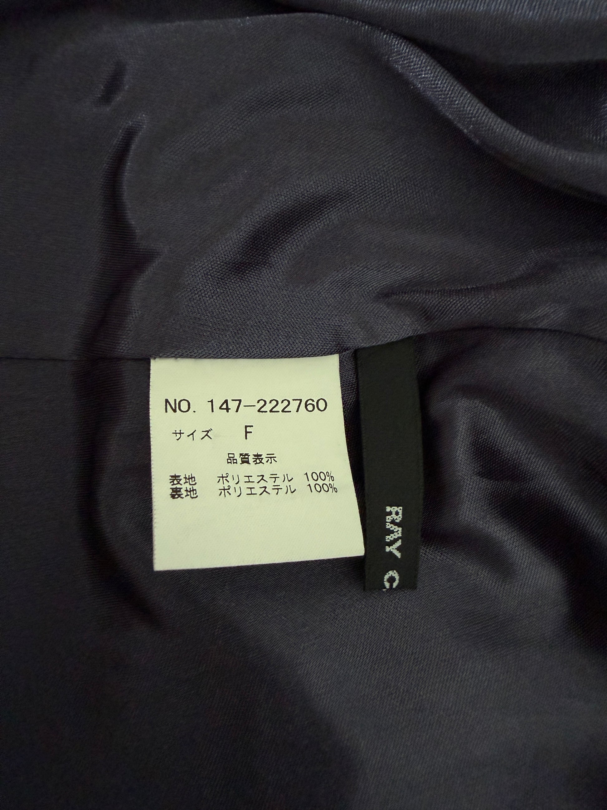 Close-up of a dark navy garment interior showing a white size label and a black Ray-Ban brand tag sewn onto the fabric.