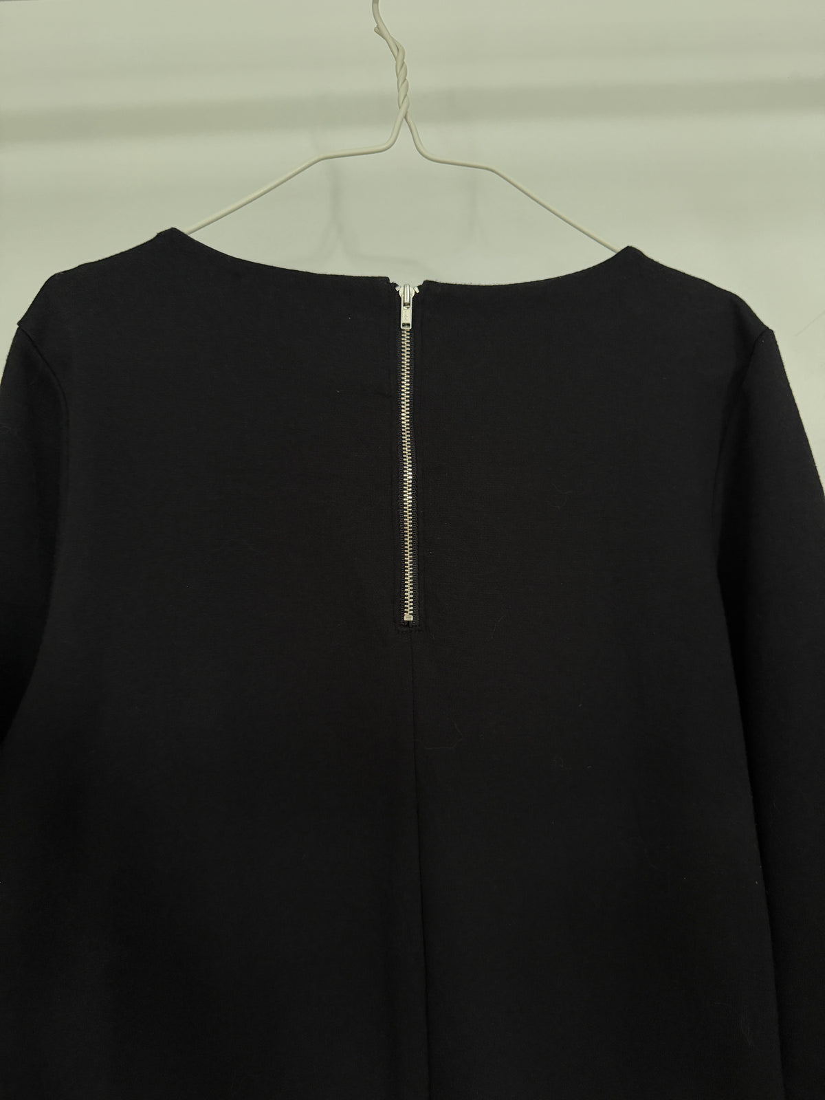 Close-up of folded black fabric with visible woven texture on a white background.