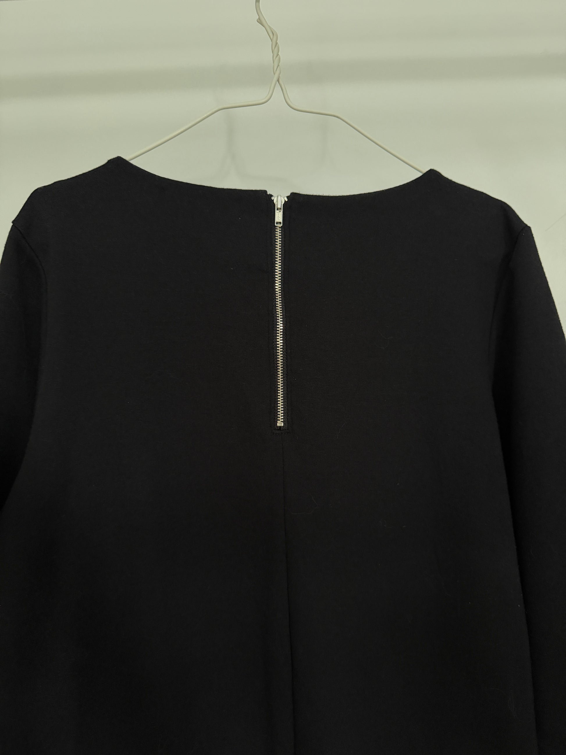 Close-up of folded black fabric with visible woven texture on a white background.