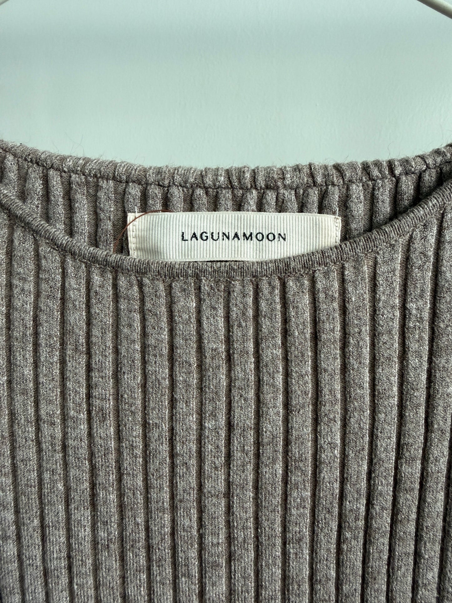 Close-up of a gray ribbed knit top with a visible LAGUNAMoon neck label, shown against a pale mint background.