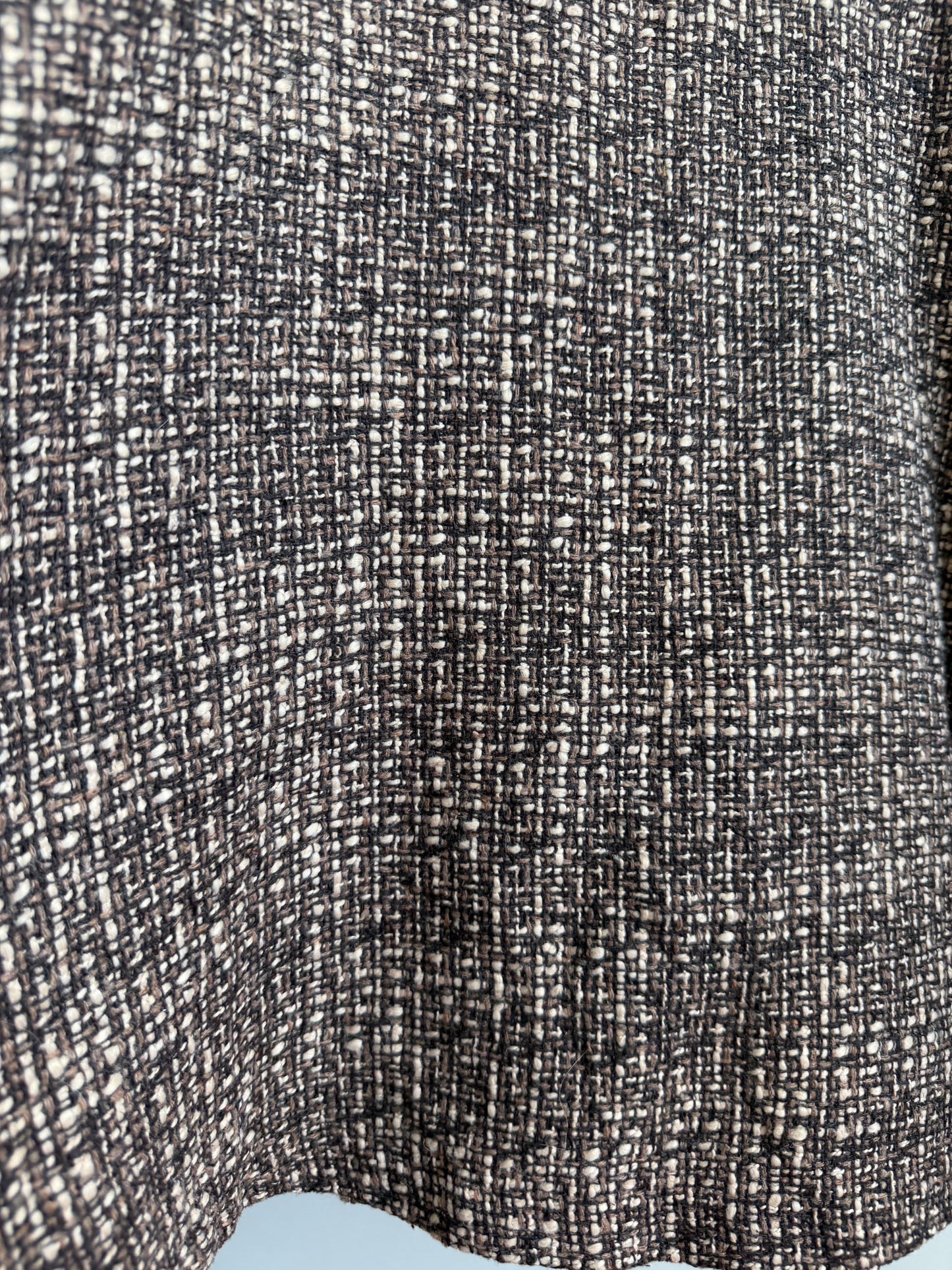 Close-up of a woven fabric texture in a black and off-white heathered pattern.